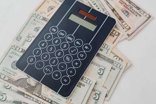 Close-up of a calculator atop US dollar bills, symbolizing financial planning and budgeting.