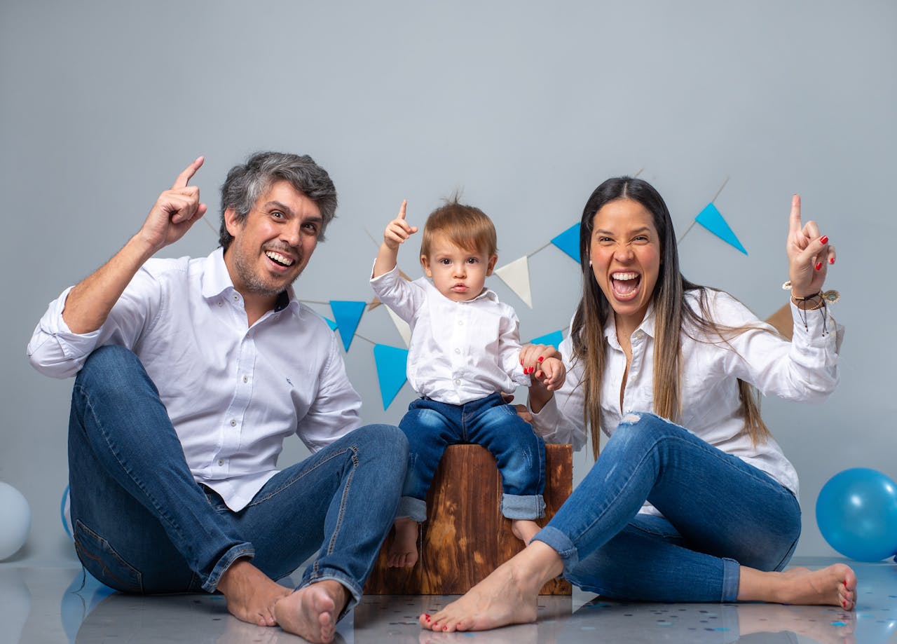 Joyful family portrait with balloons and banners, celebrating an event indoors.